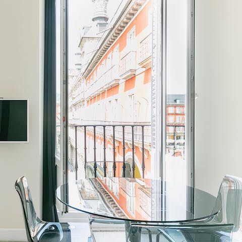 Dine in style at the glass table with your perfect view of Plaza Mayor
