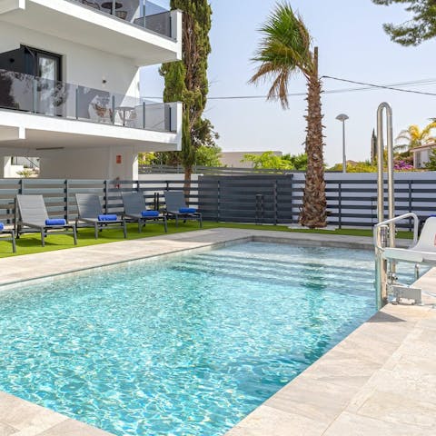 Go for a dip in the communal pool framed by palm trees