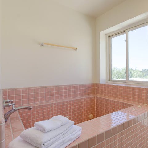 Treat yourself to a long soak in the pink tiled bath