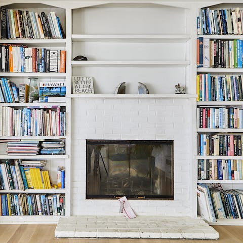A cosy fireplace surrounded by bookshelves 