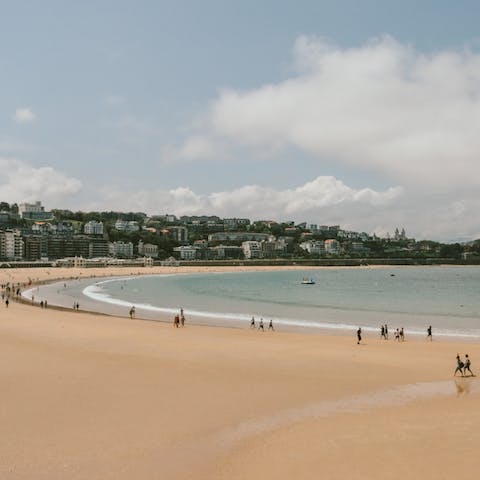 Sink your toes into the sandy beach of La Concha, a two-minute walk from your home