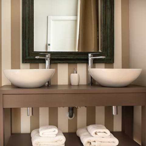 Freshen up at the double sinks in the stylish striped bathroom
