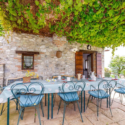 Sit down to an elegant alfresco feast beneath the vine-covered pergola