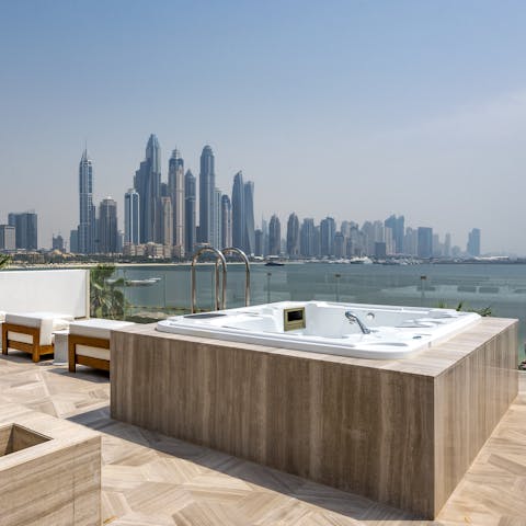 Soak away the stress in the hot tub overlooking the sea and skyline beyond