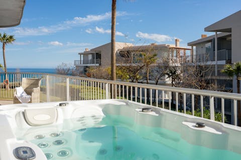 Sink into the private hot tub for a soak with a sea view