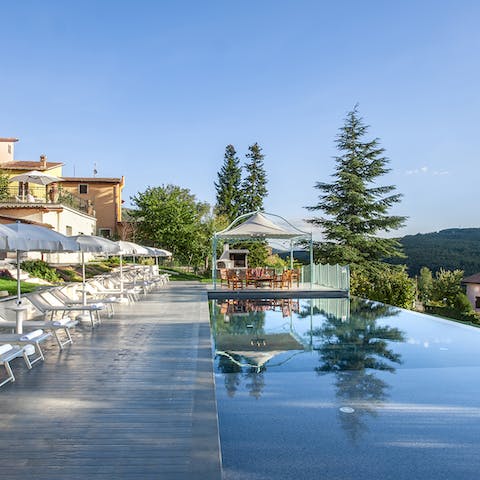 Relax by the pool on the row of sun loungers and bask in the hot sun and scenic views