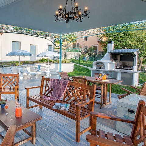 Sip cool drinks and socialise as lunch grills on the barbecue and birds sing in the trees
