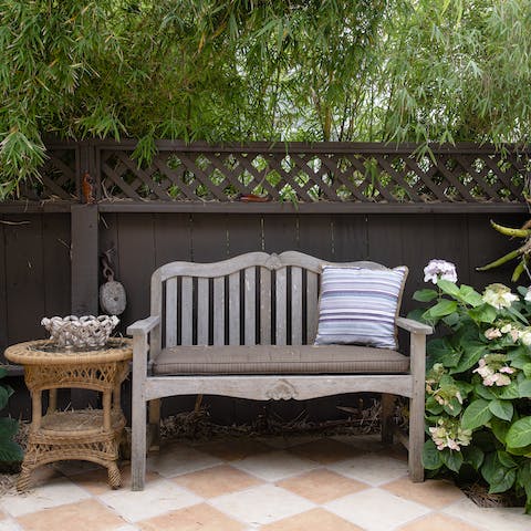 Enjoy a cold drink in the garden backed by lush greenery