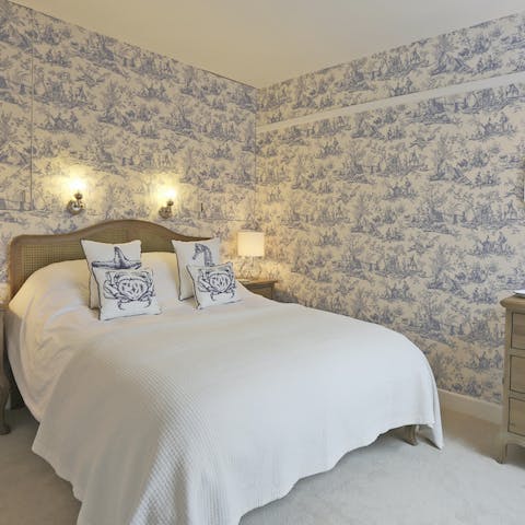 Drift off to sleep amidst the pretty willow wallpaper in the main bedroom