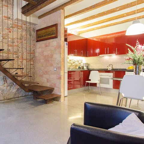 Relax with a glass of fizz in the stylish, open plan living space with its exposed brick walls and vibrant kitchen