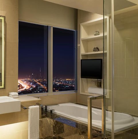 Admire the twinkling city views with a glass of wine in the bathtub