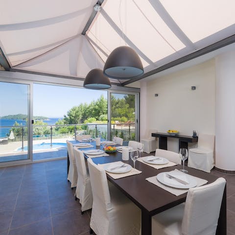 Dine with loved ones as a cool sea breeze filters into the villa