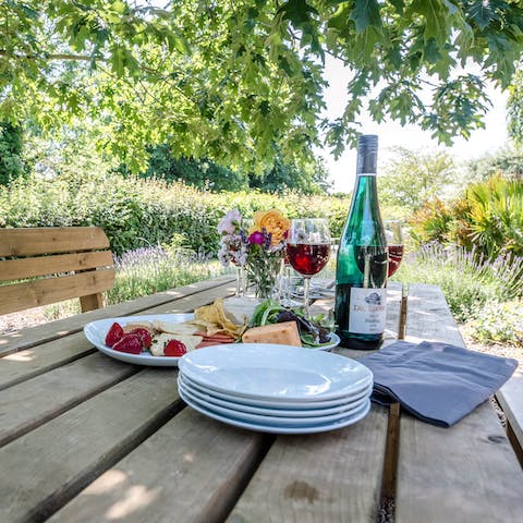Enjoy some alfresco dining at the table shaded by mature trees in the garden