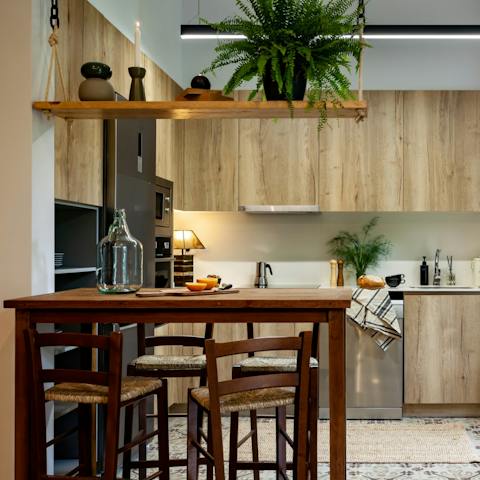 Sit down to a meal and a glass of wine in the bright kitchen area