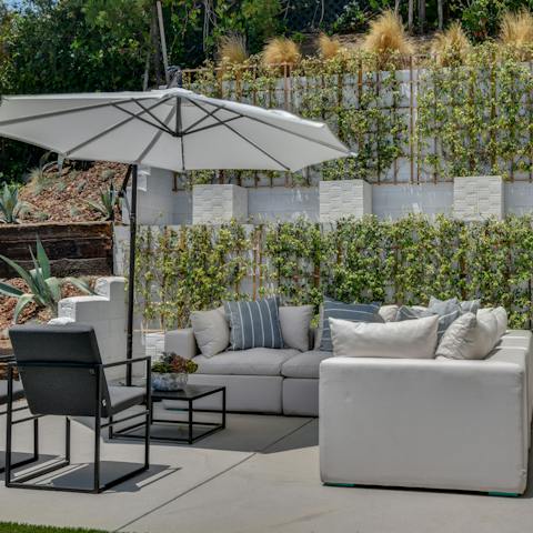 Take a break from the sun under the parasol on the patio