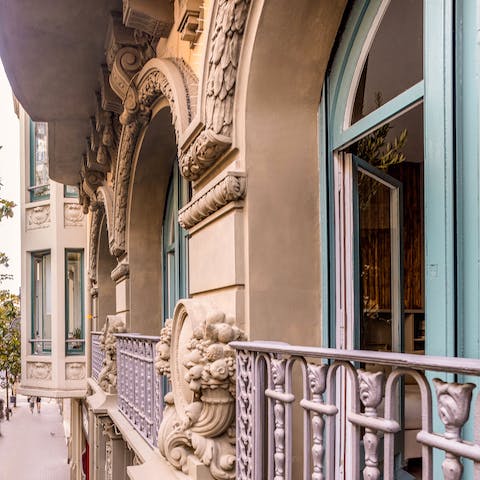 Admire the striking, decorative building from the ornate balcony