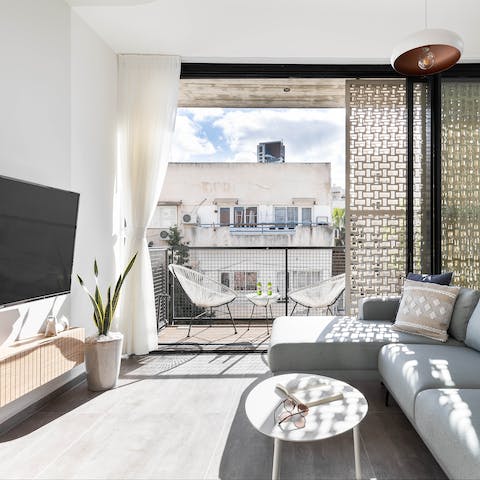 Settle in for a cosy evening of movies and wine in the bright and stylish living area