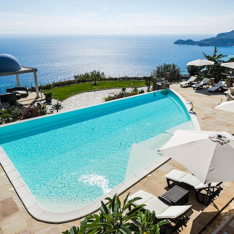Relax on the sun loungers while taking in views of the sparkling seascape