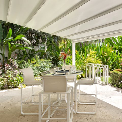 Enjoy morning coffees around the smaller outdoor table, embracing the surrounding tropics