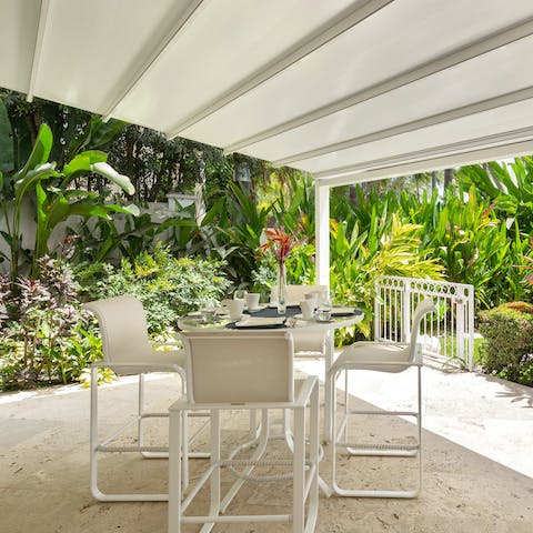 Enjoy morning coffees around the smaller outdoor table, embracing the surrounding tropics