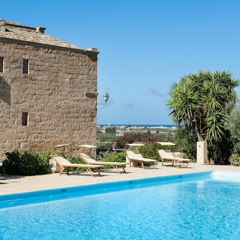 Relax on a sun lounger by the private outdoor pool with your morning coffee