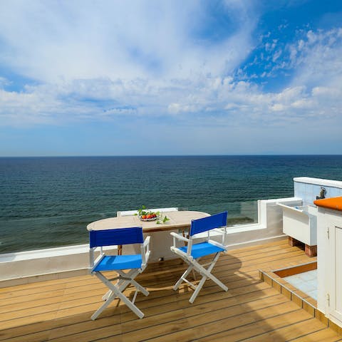 Sit down for an alfresco meal in front of the Mediterranean Sea