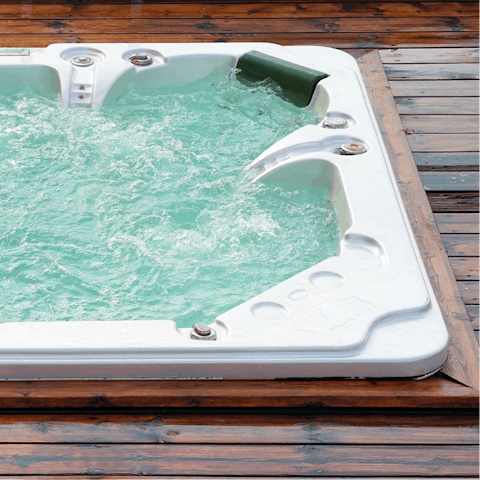 Unwind in the private hot tub, looking out at the rolling scenery 