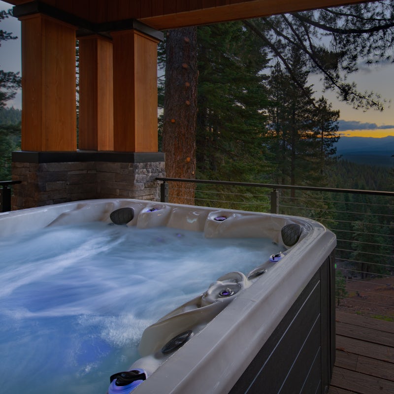 Wind down in the jacuzzi hot tub as the sun sets beyond the pines