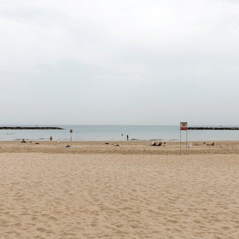 Stretch out in the sunshine on Aviv Beach, a thirteen-minute walk away