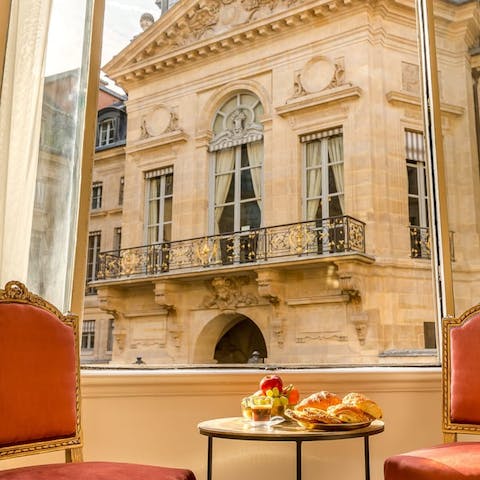 Eat a breakfast of champions featuring coffee and croissants with a view of the Louvre