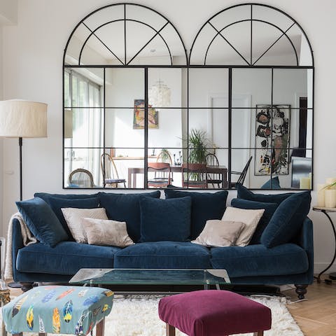 Sink into velvet furnishings in the chic living space with crittall mirrors