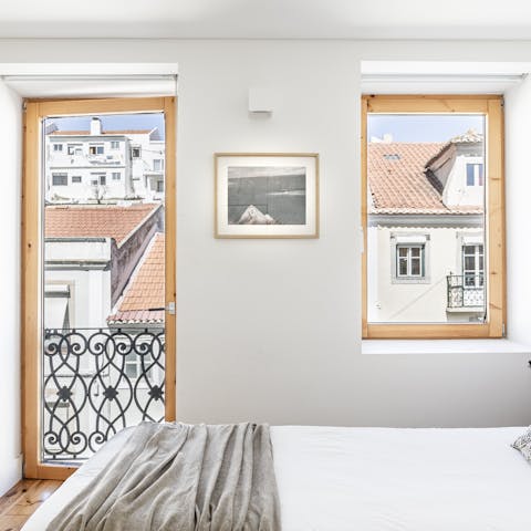 Wake up to views of Lisbon's red rooftops from the bedroom's Juliet baclony