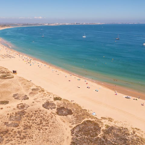Drive down to the golden stretch of Porto Mós Beach for a family day out