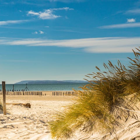 Run through soft sand dunes and paddle in the clear waters of East Wittering