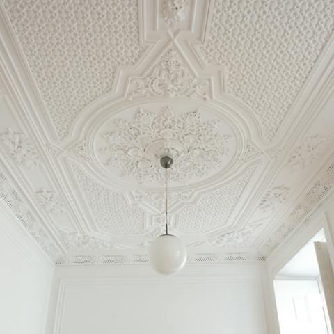 Admire the intricately corniced ceiling