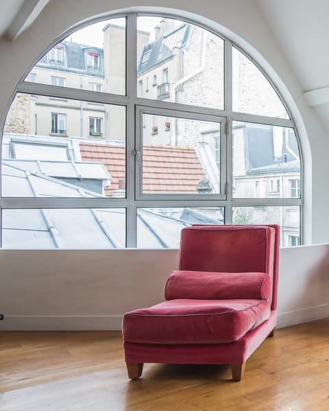Relax on the chaise longue as light floods through the huge arched window