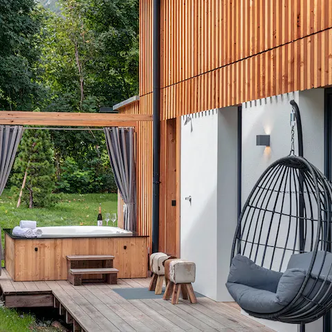 Sink into the bubbles of the hot tub and enjoy a drink, or read a book on the outdoor swing chair