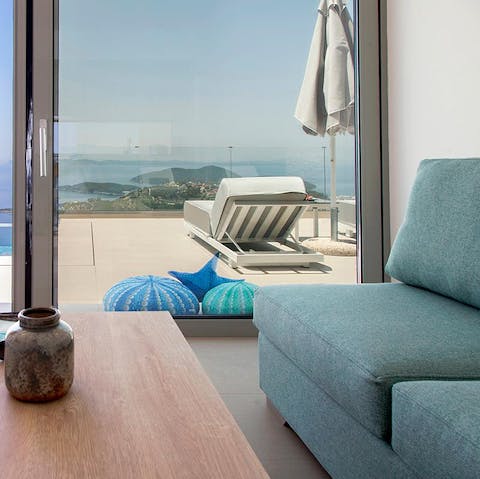 Snuggle up on the sofa and admire the ocean view from the floor-to-ceiling windows