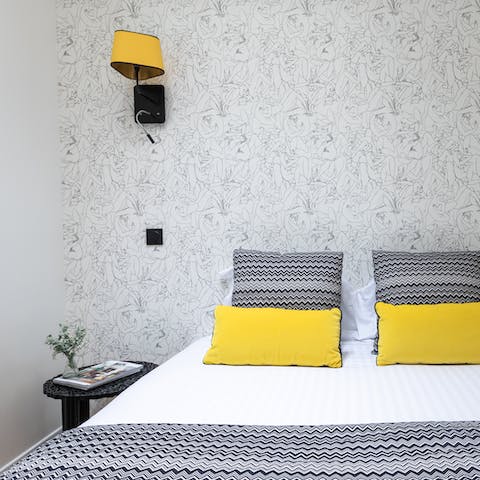 Nod off under stylish wallpaper in the comfy bedroom