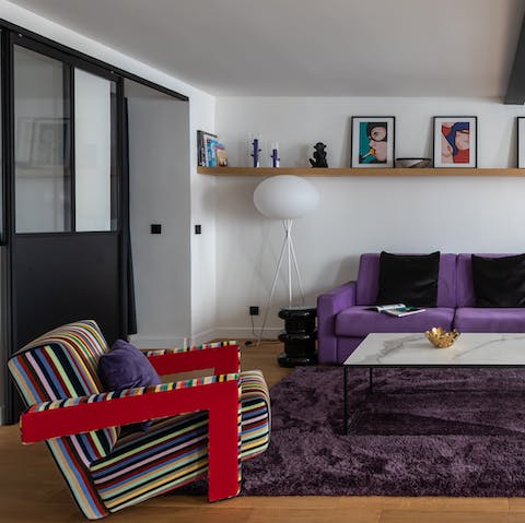 Sprawl out on the purple sofa or lounge in the striped chair after a long day