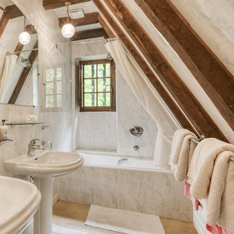 Soak in the elegant, marble tub in the eaves of your chateau