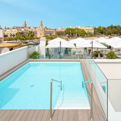 Immerse yourself in the view over the Torre del Oro from the communal pool