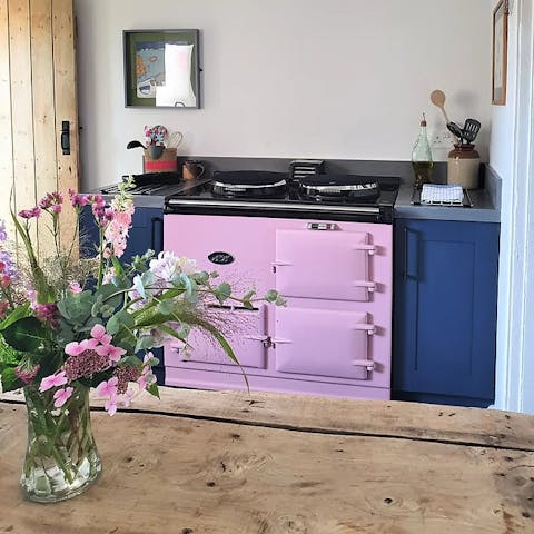 Cook up a storm on the pink Aga in the well stocked kitchen