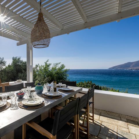 Enjoy lunch as sunlight filters through the pergola and the sea stretches before you