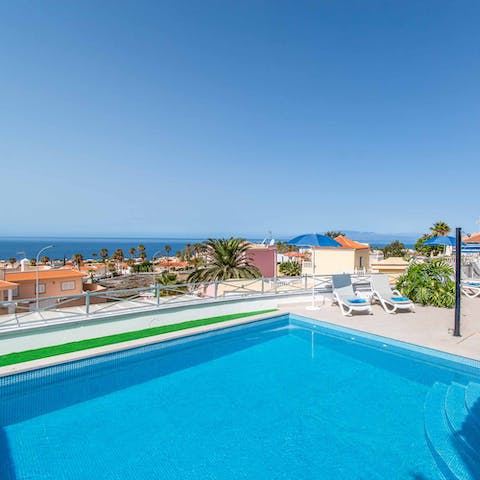 Float away the day in the swimming pool with the sea in the background