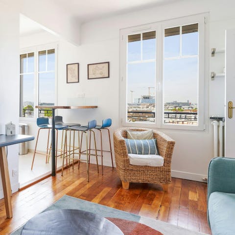Enjoy the view across Parisian rooftops from the bright living and dining space
