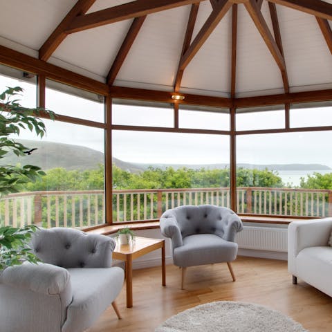 Relax in your idyllic conservatory, overlooking the rolling hills and calm sea