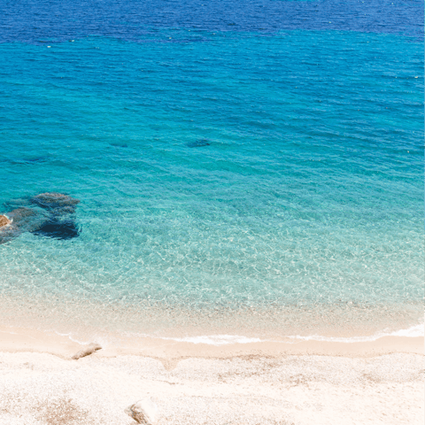 Bask in the sun on the renowned Psarou Beach, a five-minute drive away