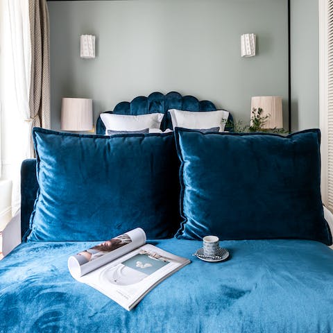 Deep blue velvet banquette at the end of the bed