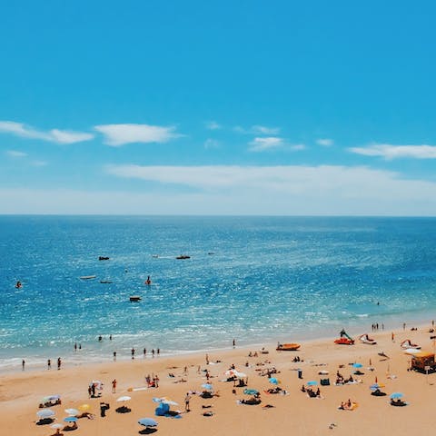 Stroll down to Praia da Coelha and listen to the waves of the Atlantic lap the shore